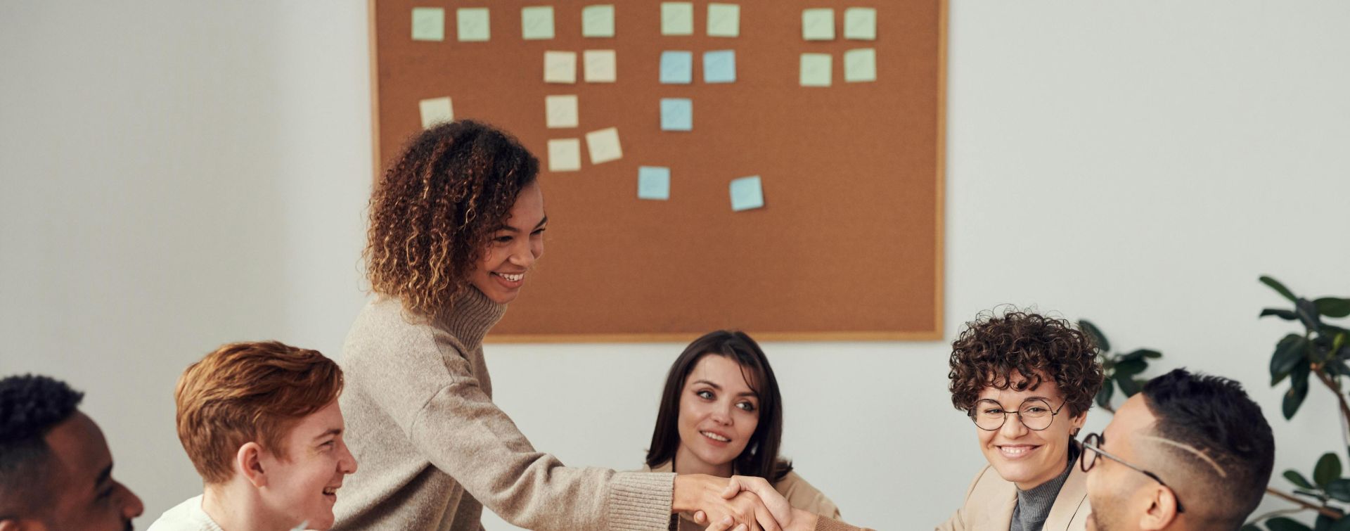 Diverse team collaborating in a meeting, showcasing teamwork and cooperation in a modern workplace.